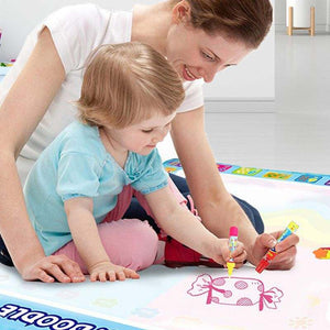 Kids playing with zero mess doodle magic water drawing mat and brush set