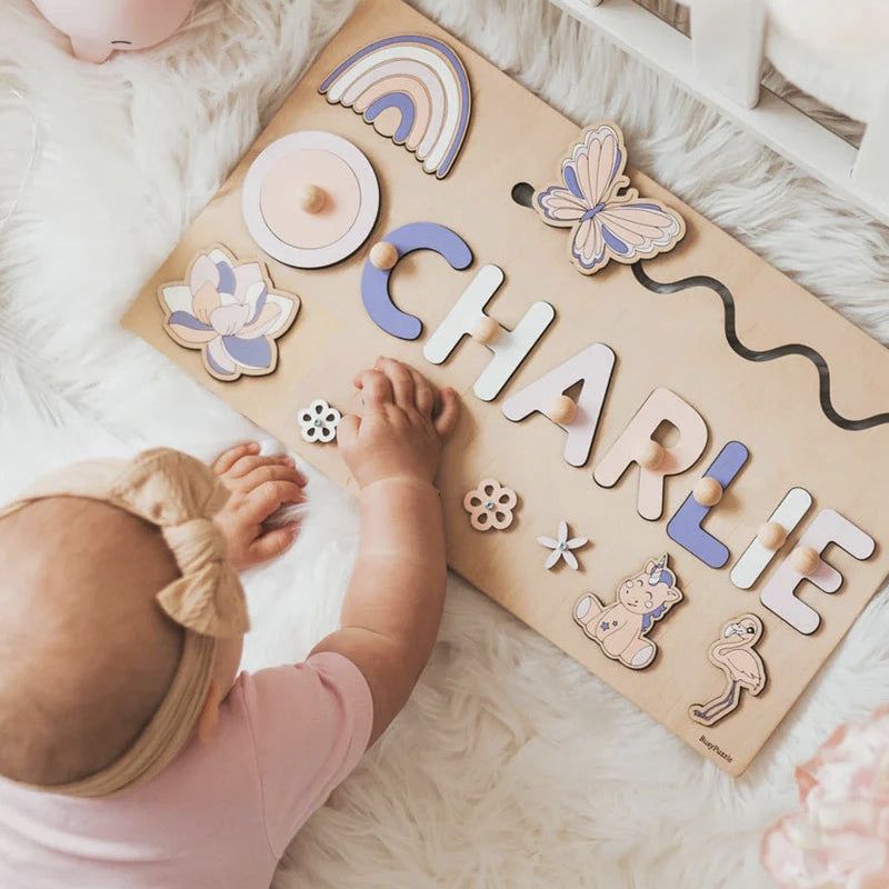 Baby playing with custom name Montessori wooden board puzzle with colorful letters and animal shapes